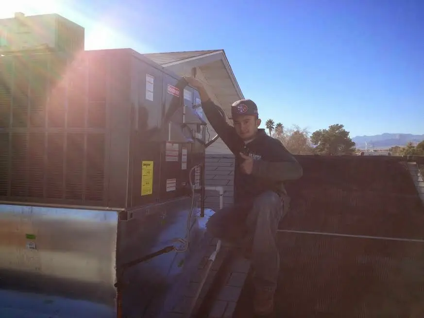 HVAC technician performing AC Tune-Up on a rooftop unit in Forsyth